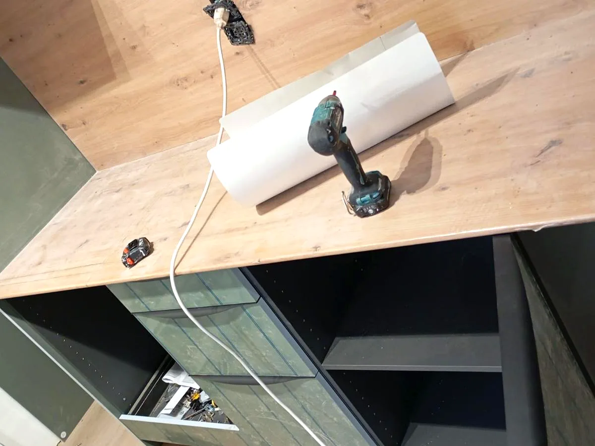 Installation of a wooden worktop and kitchen units during fitting — Grupo Topo Reformas