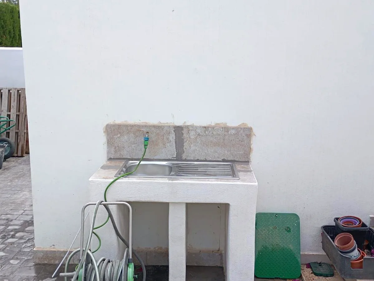 Outdoor masonry sink with stainless steel worktop installed in a courtyard — Grupo Topo Reformas