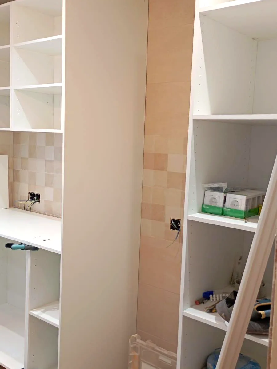 Bespoke wardrobe and shelving on site with exposed electrical installation before finishing — Grupo Topo Reformas