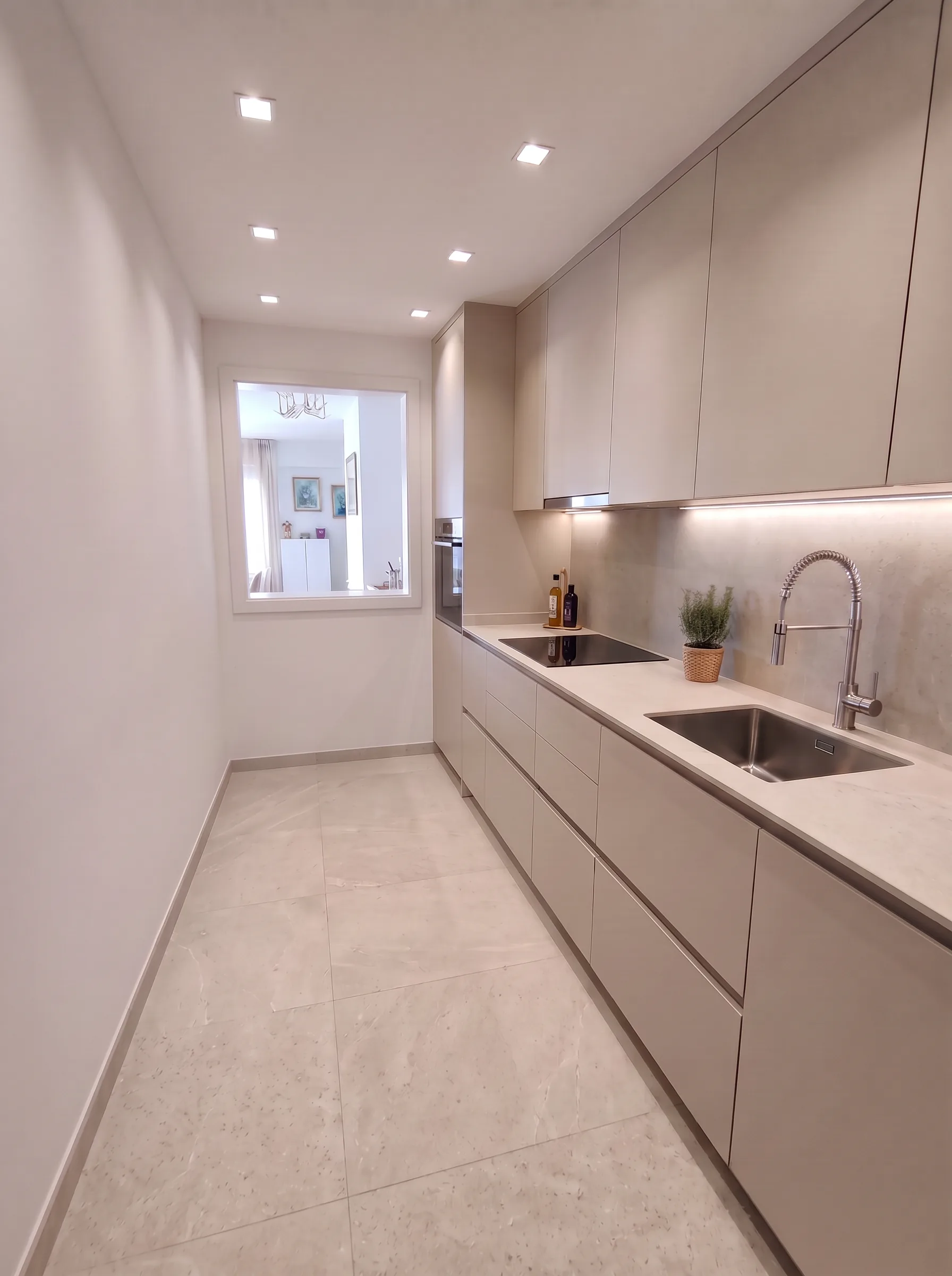 Imagen de referencia del nuevo diseño: muebles solo en la pared de la ventana, columna con horno en alto y microondas sobre bancada junto a la ventana, acabado blanco. Se ajustará una vez se compren los materiales definitivos.